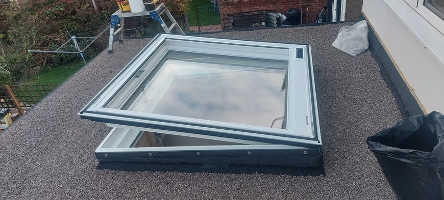 Electric flat roof Velux window with a solar powered blind.